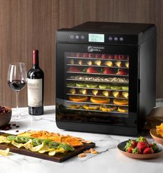 A Magic Mill food dehydrator sits on a marble countertop. It has a glass door through which a variety of sliced fruit can be seen on all of its seven shelves. Before it sits a charcuterie board with neat rows of thinly sliced dried fruits including apples and kiwis. Best Food Dehydrator, Dehydrator Machine, Food Dehydrator Machine, Royal Kitchen, Making Jerky, Dried Vegetables, Bean Casserole