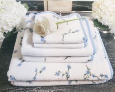 towels and flowers on a table with a mirror in the backgroung area