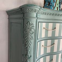 an antique dresser painted in blue and white stripes