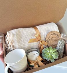 a person holding a box filled with coffee and other things to put in it's packaging