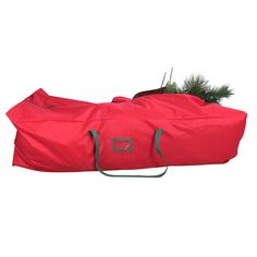 a large red bag sitting on top of a wooden table next to a potted plant