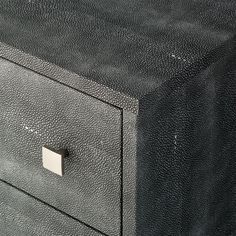 a close up of a black leather drawer with two drawers on one side and a metal handle on the other