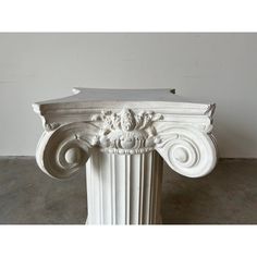 an ornate white marble column with scroll work