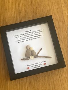 a couple of rocks sitting on top of a wooden table next to a framed photo