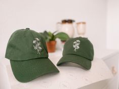 two green hats sitting on top of a white table