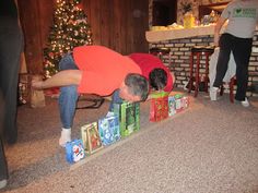 a man is bending over to pick up some christmas presents from the floor in front of him