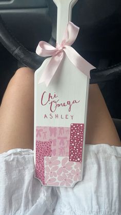 a person is sitting in a car wearing a white shirt and pink polka dot ribbon