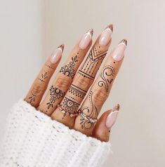 a woman's hand with hendix on it and some tattoos on her fingers