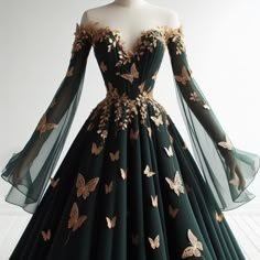 Long prom dress, Dark green, tight, A-line, off the shoulder, butterfly detailing, gold detailing, white background, on mannequin Black Butterfly Dress Prom, Long Sleeve Corset Dress Prom, Dark Green And Black Dress, Fae Ball Dress, Dark Green Dresses Prom, Butterfly Masquerade Dress, Masquerade Prom Dress Ideas, Nature Prom Dress, Masquerade Dress Ideas Prom