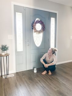 a woman kneeling on the floor in front of a door