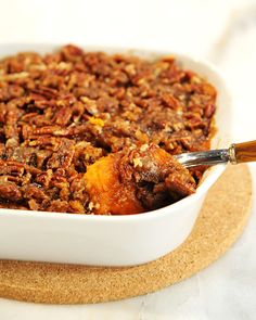 a white dish filled with pecans and other food