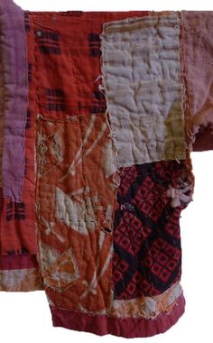 an orange and pink patchwork quilt hanging on a wall