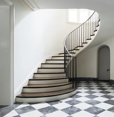 a set of stairs in an empty room with black and white checkered flooring