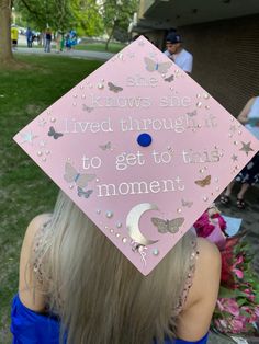 a woman wearing a pink graduation cap that says she knows she lived through it to get to this moment