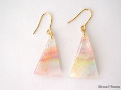 the earrings are made from glass and have gold earwires with pink, yellow and white designs on them