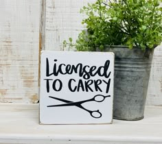 a sign that says, license to carry on it next to a potted plant