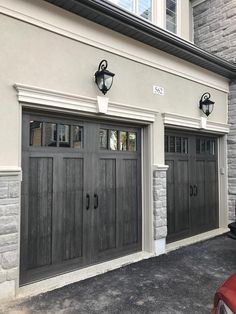 two gray garage doors on the side of a house