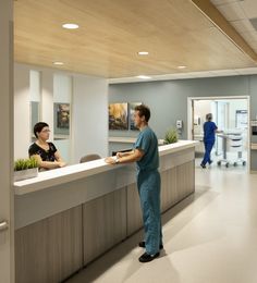 two people standing at the front desk of a medical office