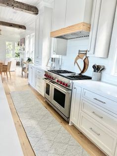 a kitchen with an oven, stove and dining room table in the backround