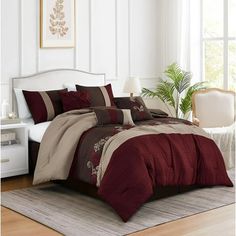 a bed with red and beige comforters in a room