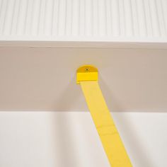 a piece of yellow tape is taped to the ceiling with a plastic adhesiver