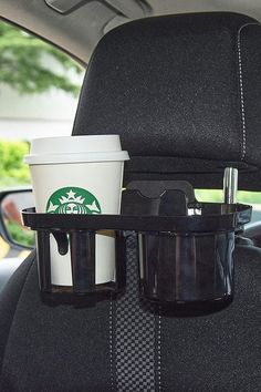 two cups on the back seat of a car, one with a cup holder attached to it