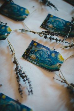 some dried flowers are sitting on a white table cloth with blue and yellow tags attached to them