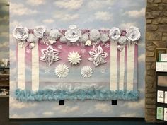 the wall is decorated with paper flowers and ribbons