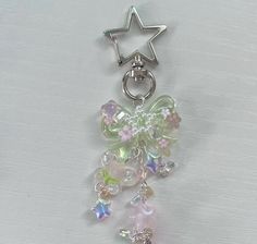 a star shaped key chain with charms hanging from it's side on a white surface