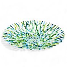 a bowl that is made out of glass and has blue, green and white stripes on it