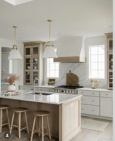 a kitchen with two stools and an island in front of the stove top oven