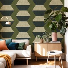 a living room with a couch, table and potted plant in front of the wall