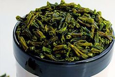 a cup filled with green tea sitting on top of a table