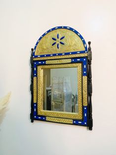 a blue and gold mirror hanging on the wall