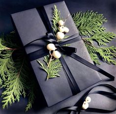 a black wrapped present with holly and berries