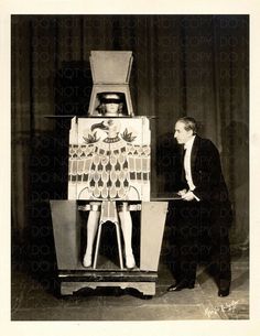 an old black and white photo of a man standing next to a statue with a woman on it