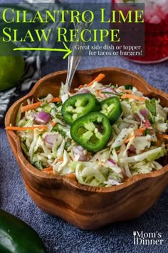 a wooden bowl filled with coleslaw slaw and topped with sliced jalapenos