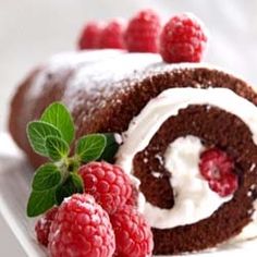 a chocolate roll with white frosting and raspberries