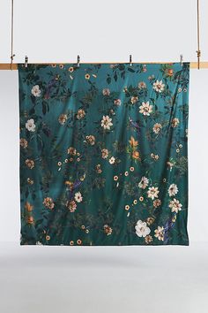 a teal floral print hanging on a wall