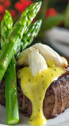 a plate with steak, asparagus and gravy on it