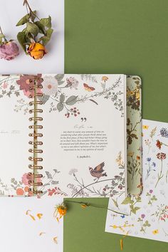 two notebooks with floral designs are next to each other on a green and white background