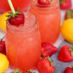 two mason jars filled with lemonade and strawberries