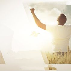 a man with his arms up in the air standing on top of a grass covered field