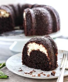 a chocolate bundt cake on a plate with a slice cut out and ready to be eaten