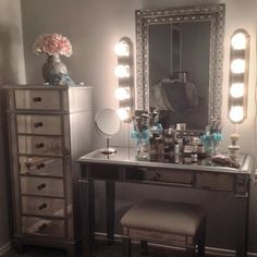 a vanity with stool, mirror and lights on it's sides in a room