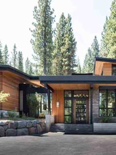 a modern house in the woods with lots of windows