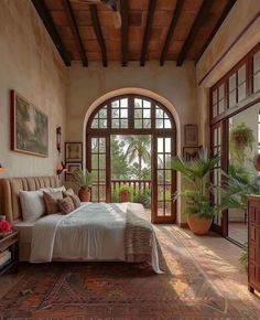 a large bedroom with an arched window and wooden furniture