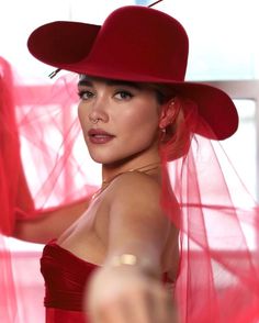 a woman wearing a red hat and veil