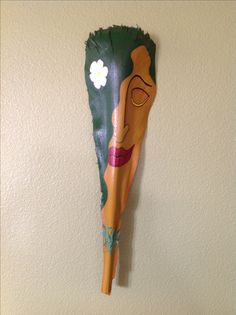 a wooden mask hanging on the wall with a flower in it's mouth,