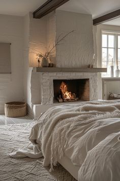 a bedroom with a fire place in the fireplace and white linens on the bed